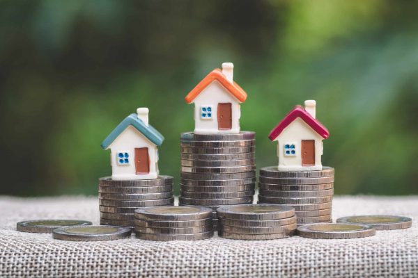 Mini,House,On,Stack,Of,Coins,,Concept,Of,Investment,Property,
