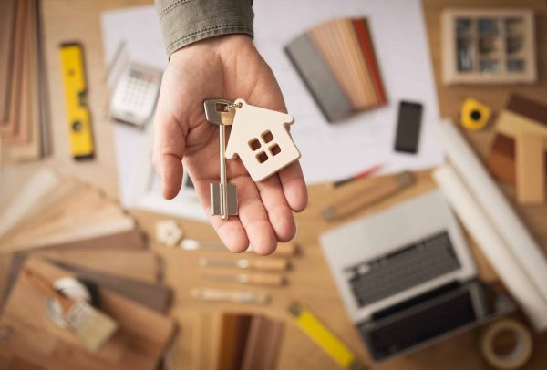 Real,Estate,Agent,Handing,Over,A,House,Key,,Desktop,With