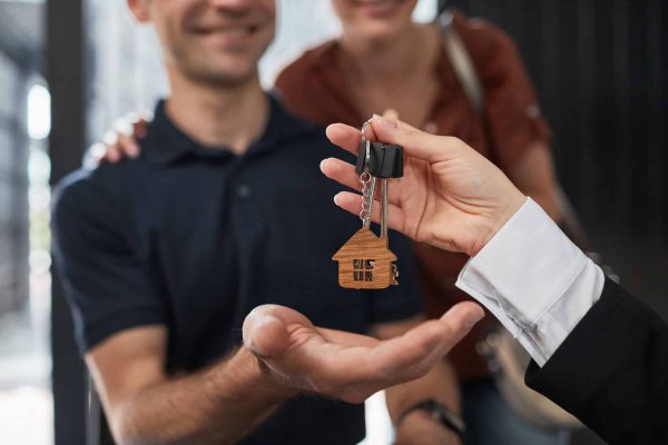 Close,Up,Of,Real,Estate,Agent,Giving,Keys,To,Couple