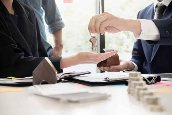 Real,Estate,Agent,Holding,House,Key,To,His,Client,After