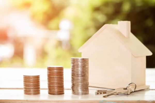 Hand,Putting,Coin,In,House,Model,Of,Coin,For,Saving